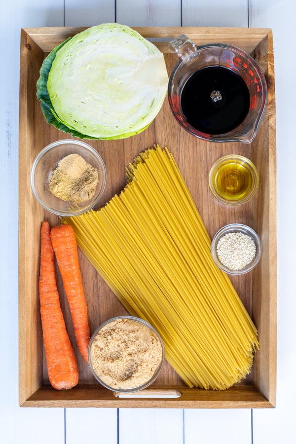 All of the ingredients needed for teriyaki noodles recipe laid out on a wooden tray.