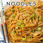 Pinterest Pin with text, One-Pot Teriyaki Noodles. Image of a large white bowl holding saucy teriyaki noodles topped with green onions sitting next to a pair of chopsticks.