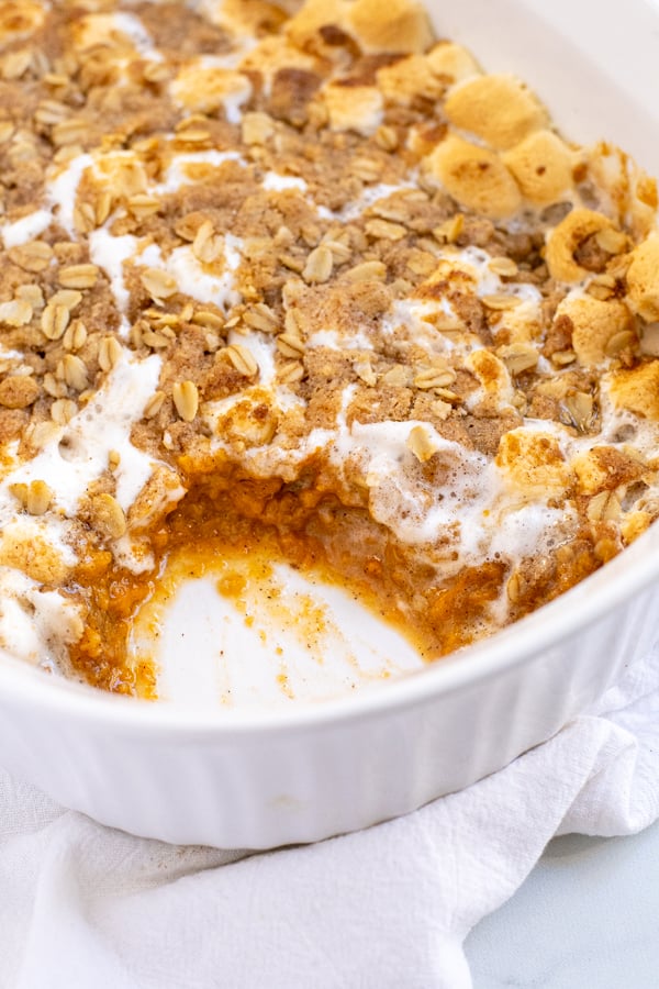 Close up of a scoop missing from Sweet Potato Casserole with Marshmallows and Oat Streusel showing the inside of the casserole.