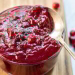 Pinterest Pin with text: How to Make Homemade Cranberry Sauce. Image of bowl of cranberry sauce next to loose cranberries.