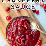 Pinterest Pin with text: Homemade Cranberry Sauce. Image of bowl of cranberry sauce next to loose cranberries.