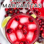 Pinterest Pin with text overlay, Cranberry Sauce Margaritas, image show close up of a bright red drink filled with ice and cranberries.