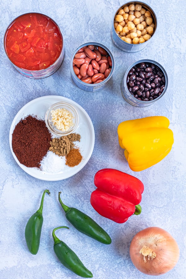 Ingredients needed to make slow cooker vegetarian chili all laid out on a table.