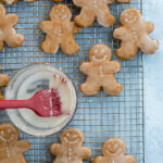 Pinterest Pin with text overlay, Soft Glazed Gingerbread Cookies. Image of gingerbread cookies on a wire rack.