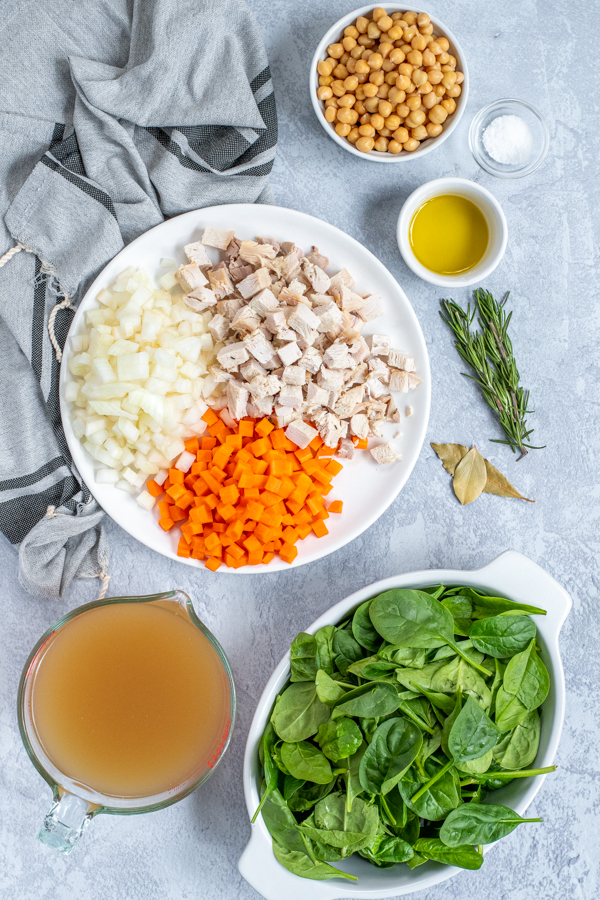 All of the ingredients need to make a healthy leftover turkey soup laid out on a table.