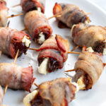 Pinterest Pin with Image of bacon wrapped dates placed on a white plate.