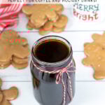 Pinterest Pin with text overlay 'Gingerbread Simple Syrup Perfect for Coffee and Holiday Drinks'. Image of a glass jar of dark colored syrup tied up with a red and white bow.