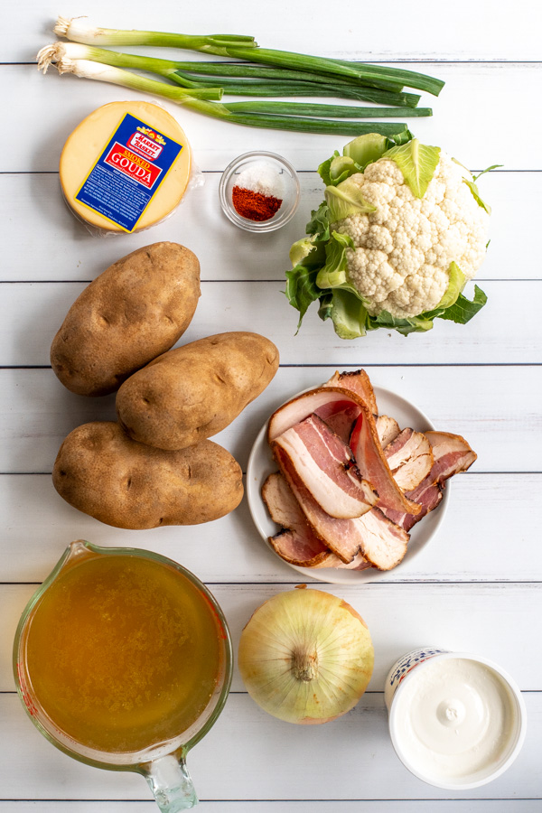 Ingredients needed to make loaded baked potato soup sitting on a white background.