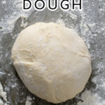 Pinterest Pin with text overlay 'Homemade Pizza Dough'. Image of a ball of floured dough on a countertop.