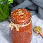 Pinterest pin with text overlay 'Pizza Sauce ready in under 5 minutes'. Image of sauce filled to the top of a glass jar.