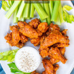 Pinterest Pin with text overlay 'Pressure Cooker Hot Wings'. Image of platter with pile of saucy chicken wings next to dipping sauce.