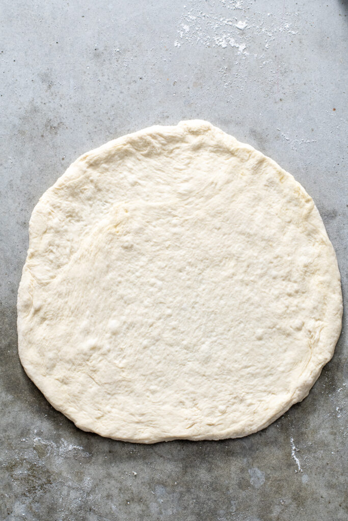 Pizza dough shaped into a circle.