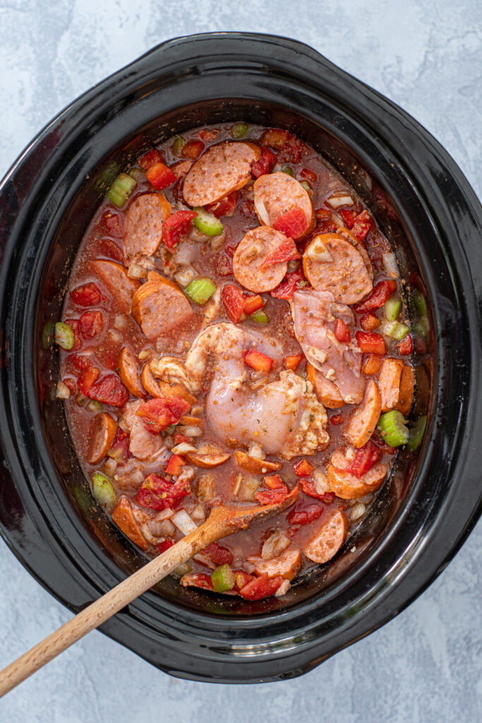 All the ingredients except shrimp stirred together in a crockpot ready to be cooked.