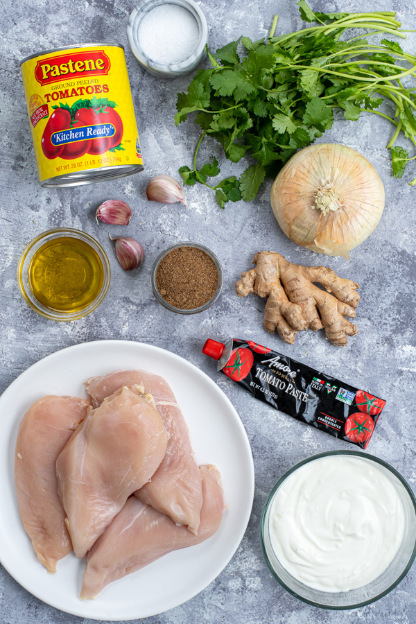 All the ingredients needed to make chicken tikka masala laid out on a table top.