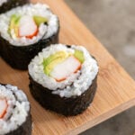 Pinterest Pin with text overlay 'Easy to make California Sushi Rolls', images of sushi on a serving platter.