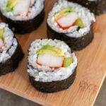 Pinterest Pin with text overlay 'How to make Homemade California Sushi Rolls', image of bamboo serving tray with sushi rolls.