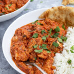 Pinterest Pin with text overlay 'Chicken Tikka Masala made with no heavy cream', image of bowl of chicken tikka masala next to a bed of rice.