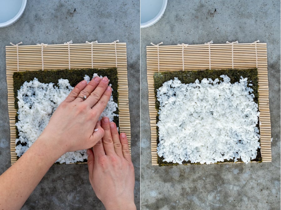 Step two of rolling sushi spreading out the rice with wet fingers to cover the seaweed nori.
