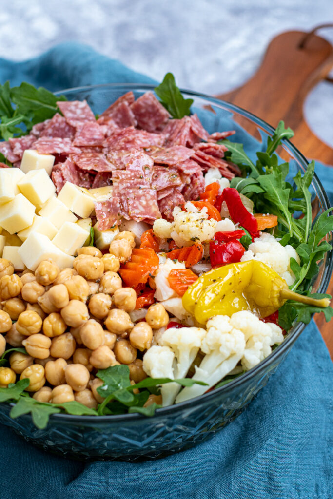 Dressed topping over a bed of arugula make up this easy antipasto salad.