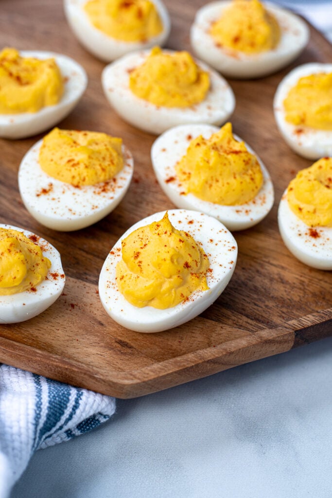 Close up of a deviled egg on a platter showing off the paprika garnish.