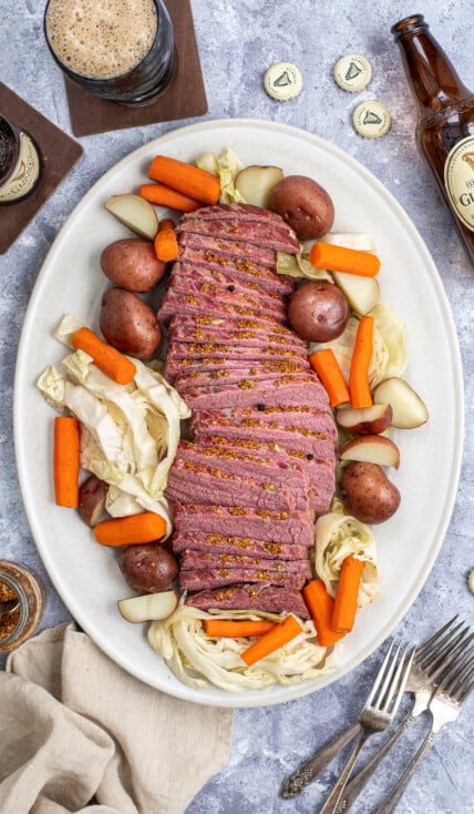 A platter filled with Guinness Corned Beef and Cabbage with carrots and potatoes.