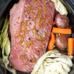 Pinterest Pin with text 'Crockpot Guinness Corned Beef', Image of crockpot with corned beef and vegetables.