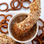 Pinterest Pin with text 'Pretzel Crusted Chicken Tenders', image of stack of chicken tenders on a plate next to honey mustard.