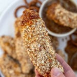 Pinterest Pin with text 'Pretzel Crusted Chicken Tenders', image of stack of chicken tenders on a plate next to honey mustard.