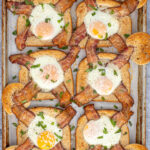 Pinterest Pin with text overlay 'Sheet Pan Egg in a Hole', image of a sheet pan with six baked egg in a hole toasts' with bacon.