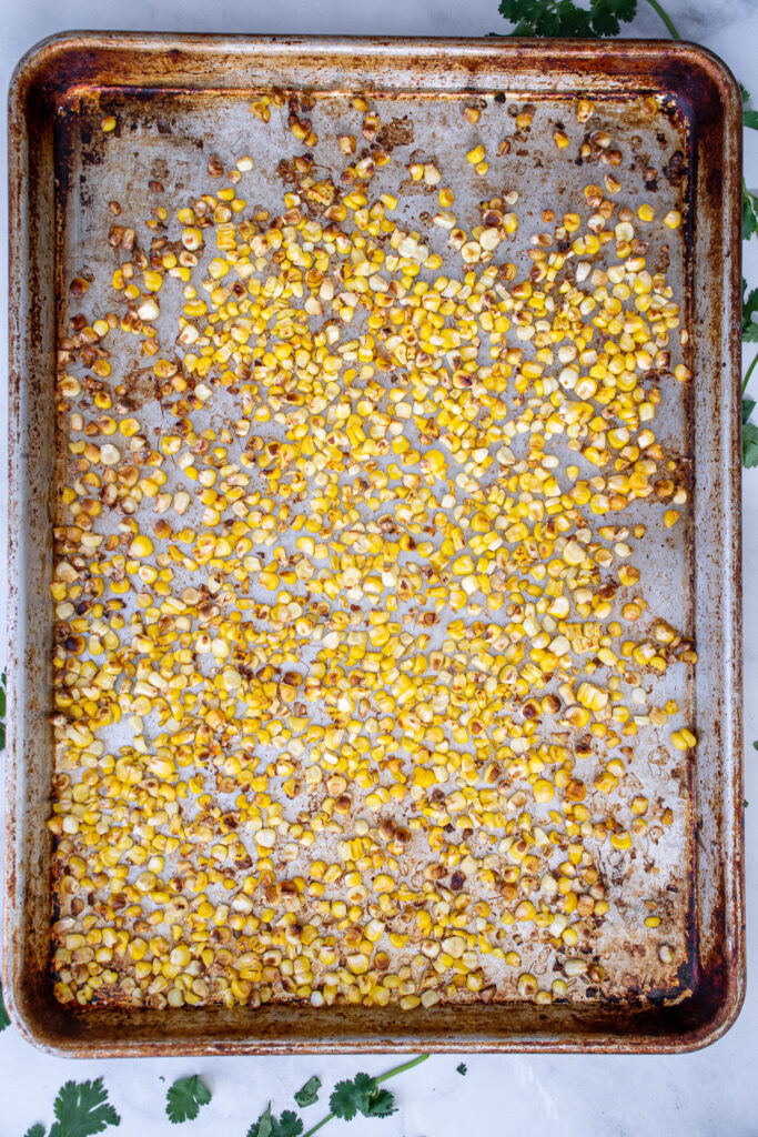 Sheet pan with blistered corn kernels.