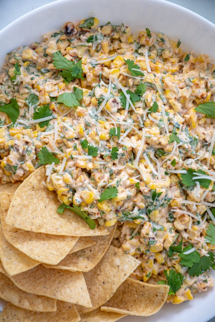 Close up view on corn, parmesan cheese, and cilantro in a a quick and easy corn dip recipe.
