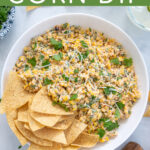 Pinterest Pin with text 'Mexican Street Corn Dip', image of street corn dip in a white bowl with tortilla chips.