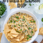 Pinterest Pin with text 'Mexican Street Corn Dip', image of street corn dip in a white bowl with tortilla chips.