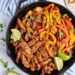 Pinterest Pin with text 'Skillet the best Chicken Fajitas', image of a cast iron filled with chicken and brightly colored bell peppers.