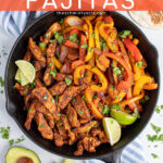 Pinterest Pin with text 'Chicken Fajitas', image of a cast iron filled with chicken and brightly colored bell peppers.