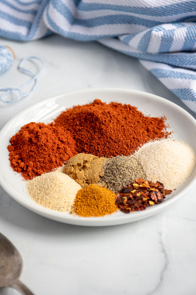 Small white plate with mounds of different colored spices.