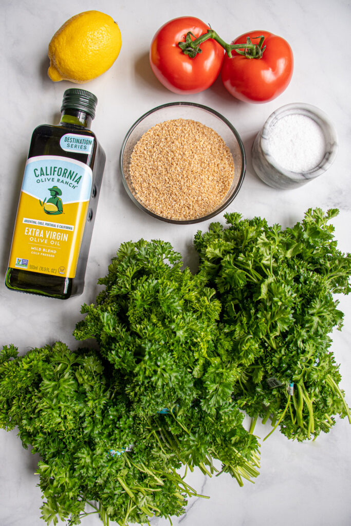 Ingredinets needed to make basic tabbouleh salad laid out on a table top.