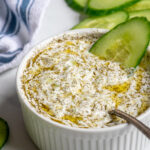 Pinterest Pin with text overlay 'The Best Homemade Tzatziki Sauce', image of small white bowl filled with homemade tzatziki sauce.