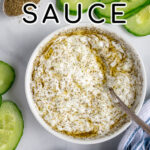 Pinterest Pin with text overlay 'Tzatziki Sauce', image of small white bowl filled with homemade tzatziki sauce.