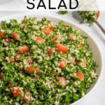Pinterest Pin with text 'Tabbouleh Salad', image of a large white bowl of tabbouleh salad with parsley, bulgur, and tomatoes.