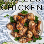 Pinterest Pin with text 'Greek Marinated Grilled Chicken', image of a plate piled high with golden brown grilled chicken legs.