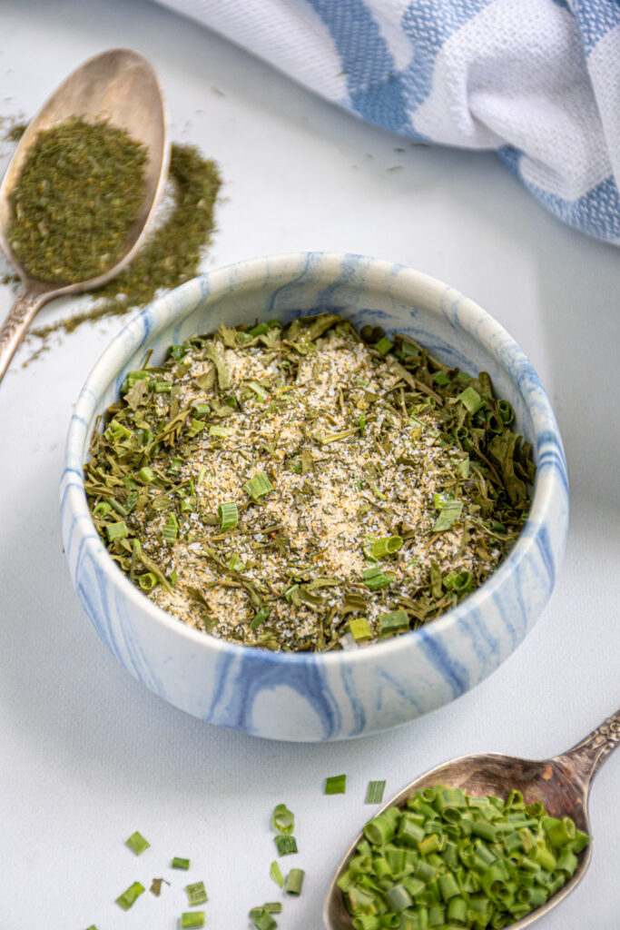 A small blue and white bowl of ranch seasoning mix sitting on a table.