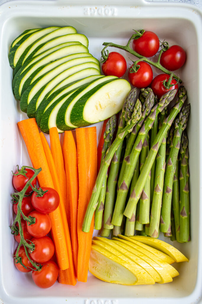 Cut vegetables placed nicely in a white baking dish.