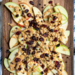 Pinterest pin with text 'Healthy Apple Nachos', image showing cutting board layered with apples and toppings.