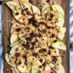 Pinterest pin with text 'Healthy Apple Nachos', image showing cutting board layered with apples and toppings.