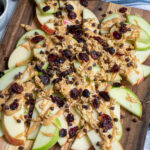Pinterest pin with text 'Healthy Apple Nachos', image showing cutting board layered with apples and toppings.