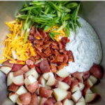 Pinterest Pin with text 'Healthy Bacon Ranch Potato Salad', image of stainless steel bowl with ingredients inside.
