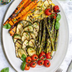 Pinterest pin with text 'Marinated & Grilled Vegetables', image of a platter filled with freshly grilled veggies laid out nicely on a platter.