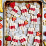 Pinterest Pin with text 'Parfait Breakfast Popsicles', image of a sheet tray filled with red and white layered popsicles.