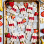 Pinterest Pin with text 'Healthy Parfait Breakfast Popsicles', image of a sheet tray filled with red and white layered popsicles.